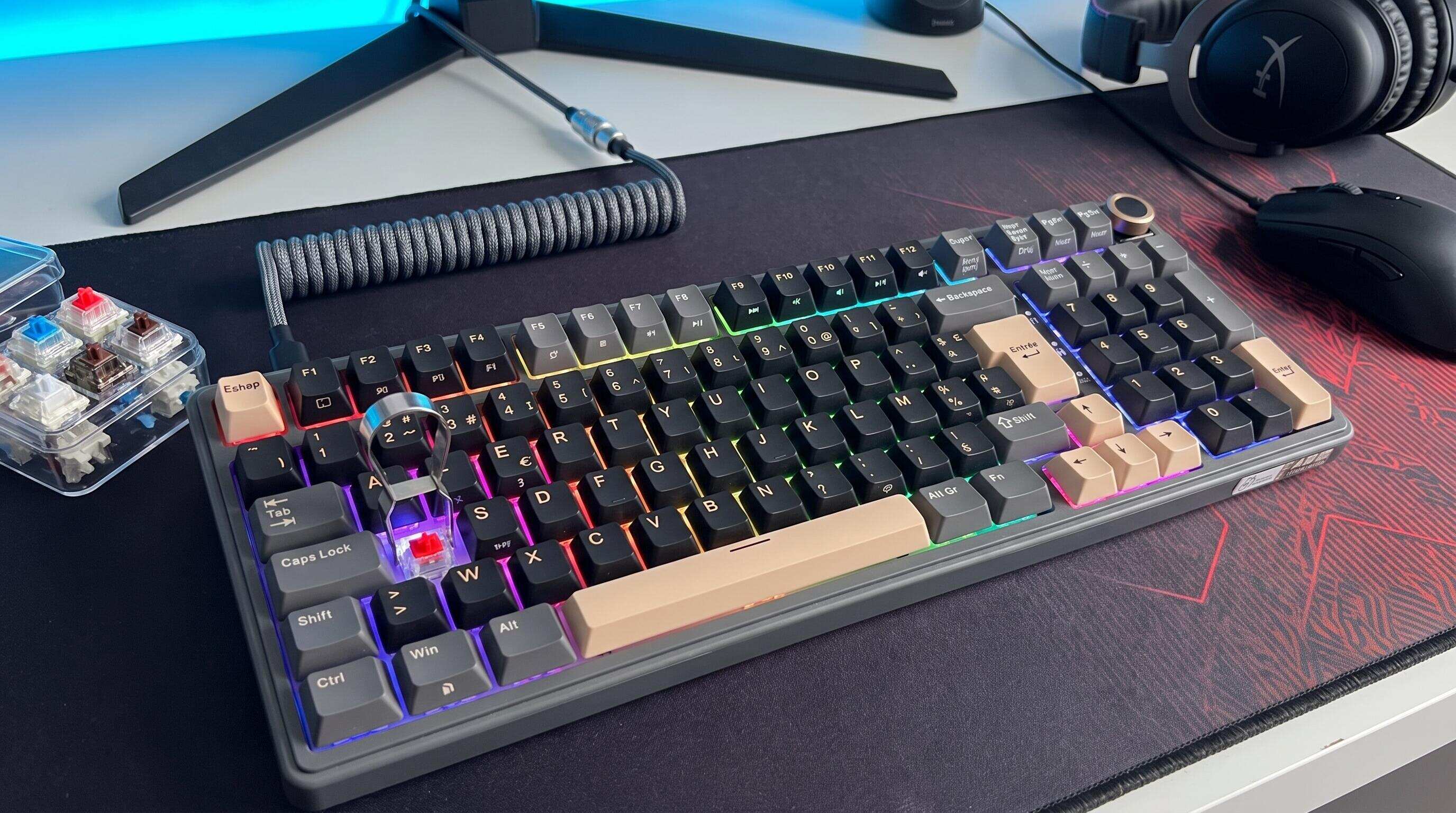 Extracteur de switch et switches mécaniques posés sur un bureau à côté d'un clavier Royal Kludge prêt pour le hot-swap
