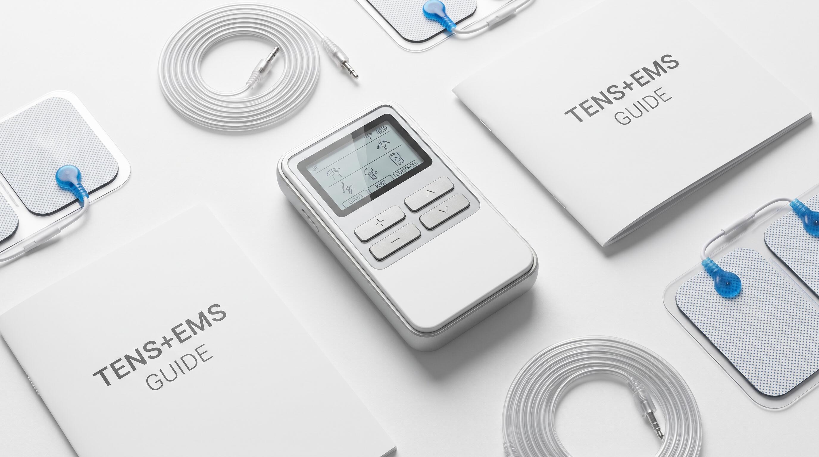 A TENS EMS combo unit with electrode pads laid out on a table, ready for a family home therapy session